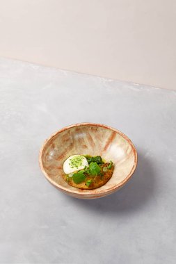 Kremalı omlet, ıspanak şerbeti ve yeşil yapraklı. Gri taş arka planda ev yapımı seramik kasede omlet. Seramik hala hayat. Modern servis malzemelerinde kahvaltı