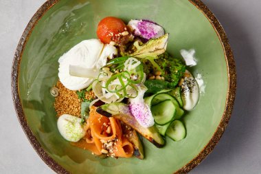 Somon, avokado, brokoli, sebze ve yumurta ile ev yapımı seramik tabakta salata kasesi. Modern servis takımında somon, brokoli ve kinoa ile Buda kasesi. Beton zeminde modern seramik bulaşık takımı