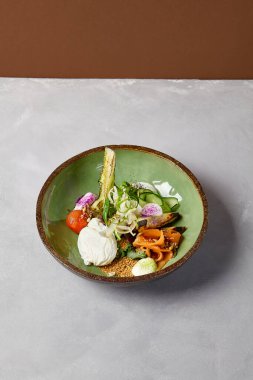 Somon, avokado, brokoli, sebze ve yumurta ile ev yapımı seramik tabakta salata kasesi. Modern servis takımında somon, brokoli ve kinoa ile Buda kasesi. Beton zeminde modern seramik bulaşık takımı