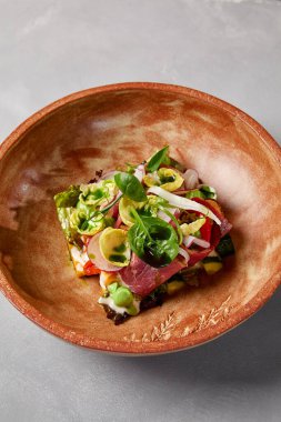 Pastırmalı salata, sebze ve el yapımı seramik kasede sos. Gri taşlı arka planda modern bulaşık takımında biftek ve sebze salatası. Şef 'ten çağdaş yemek. El yapımı yemek tabağı.