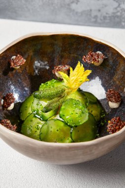 El yapımı seramik kasede salatalık turşusu. Yenilikçi tariflerde taze salatalık ve cornichon dilimleri.