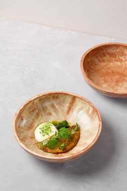 Kremalı omlet, ıspanak şerbeti ve yeşil yapraklı. Gri taş arka planda ev yapımı seramik kasede omlet. Seramik hala hayat. Modern servis malzemelerinde kahvaltı