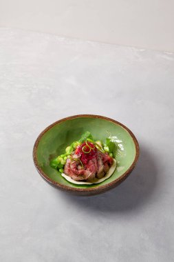 Aperatif, soslu biftek, salatalık ve seramik kasede soğan. Modern seramik bulaşık takımında biftek. El yapımı yemek tabağı. Modern yemek, el yapımı bulaşık takımı.