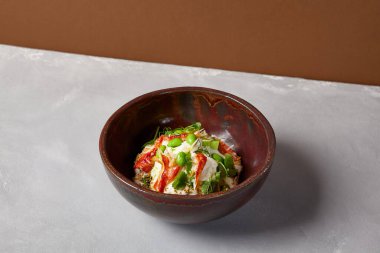 Yengeçli aşçı salatası, kinoa, sebze ve ev yapımı koyu seramik kasede edamame fasulyesi. Yengeçli salata kasesi, avokado, modern servis malzemelerinde krema sosu. Beton zeminde modern bulaşık malzemesi