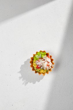 Beyaz masadaki sert gölgeli yengeçli aperatif. Yiyecek ve şarap bardağı gölgesi. Güzel yemeklerde deniz mahsullü tart. Yaşam tarzı yaz yemekleri.