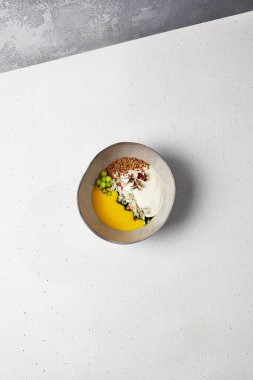 El yapımı seramik kasede yengeçli balkabağı çorbası. Yenilikçi tarifler. Beyaz beton arka planda yengeç ve peynir espumalı krema çorbası. Bulaşık takımında modern yemek