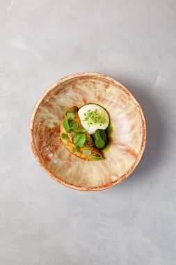 Kremalı omlet, ıspanak şerbeti ve yeşil yapraklı. Gri taş arka planda ev yapımı seramik kasede omlet. Seramik hala hayat. Modern servis malzemelerinde kahvaltı