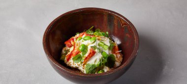 Yengeçli aşçı salatası, kinoa, sebze ve ev yapımı koyu seramik kasede edamame fasulyesi. Yengeçli salata kasesi, avokado, modern servis malzemelerinde krema sosu. Beton zeminde modern bulaşık malzemesi