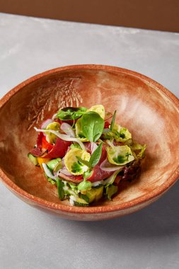 Pastırmalı salata, sebze ve el yapımı seramik kasede sos. Gri taşlı arka planda modern bulaşık takımında biftek ve sebze salatası. Şef 'ten çağdaş yemek. El yapımı yemek tabağı.