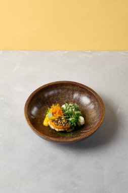 Tavuklu kabak bifteği ve koyu seramik tabakta ıspanak. Modern bulaşık takımında sağlıklı yiyecekler. Modern tarzda yenilikçi tarifler. Gri arka planda balkabağı olan kızarmış hindi.