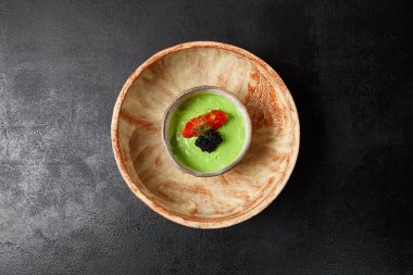 Domates ve havyarlı avokado kreması. El yapımı seramik kasede Guacamole sosu. Modern yemek, avokado sosu. Avokado için sağlıklı mezeler. Vejetaryen yemeği.