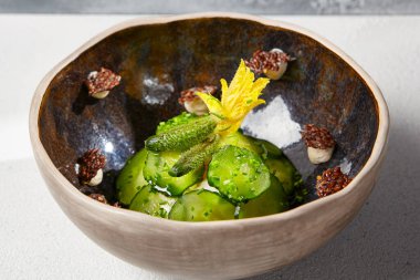 El yapımı seramik kasede salatalık turşusu. Yenilikçi tariflerde taze salatalık ve cornichon dilimleri.