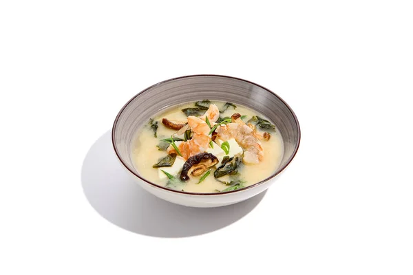 日本菜汤 配以豆腐 虾和蘑菇 独立白底陶瓷碗中的虾米苏汤 免版税图库照片