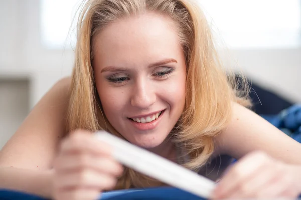 Schöne junge Frau im Schlafzimmer glücklich wegen der Schwangerschaft — Stockfoto