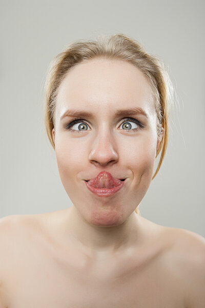 funny portrait of young woman trying to lick her nose, dorky silly