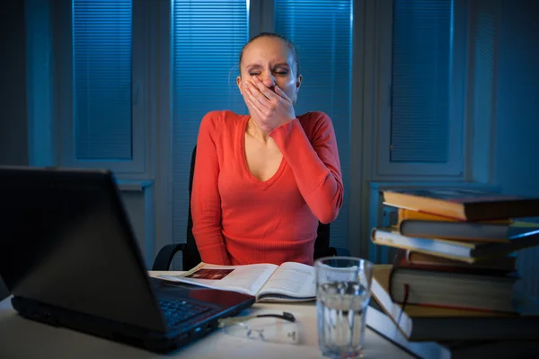 Junge gelangweilte College-Studentin studiert am späten Abend schlecht lizenzfreie Stockfotos