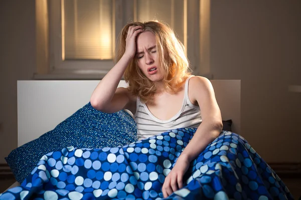 Junge kaukasische Frau mit Kopfschmerzdepression und Kater im Bett — Stockfoto