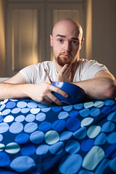 Hombre joven en la cama con dolor de cabeza depresión y bostezo resaca — Foto de Stock