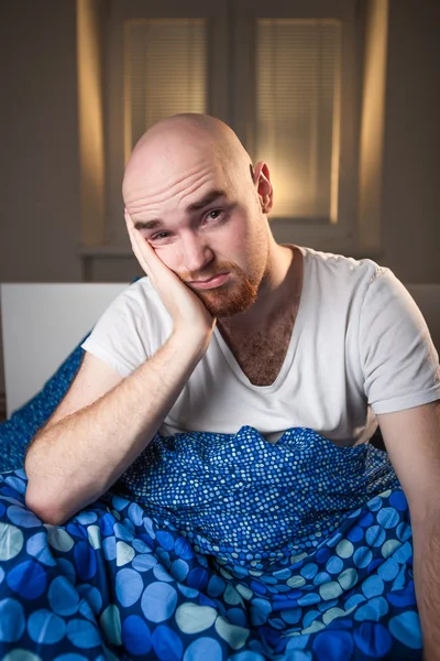 Young man in bed with headache depression and hangover yawning — Stock Photo, Image