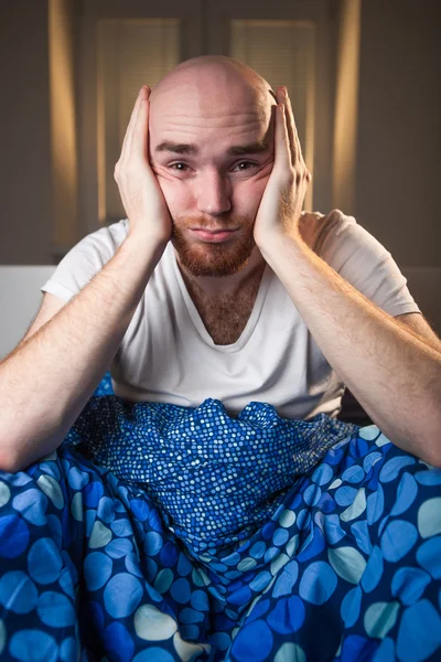 Junger Mann mit Kopfschmerzdepression und Kater-Gähnen im Bett — Stockfoto
