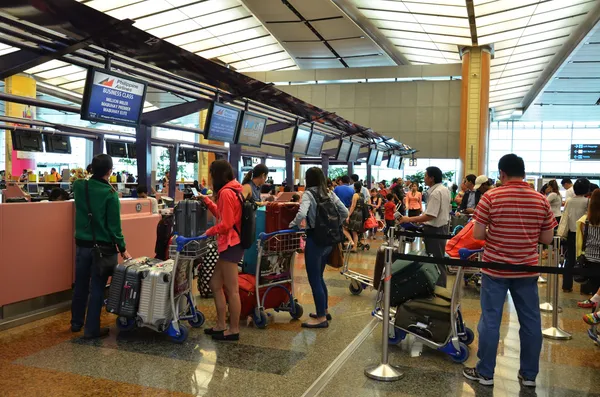 Singapur havaalanında bilet satan cephede sırada turist