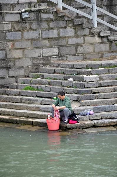 Chinese women washes cloth on the river bank — Stock Photo, Image