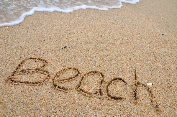 Stranden ord skrivet på sandstranden — Stockfoto