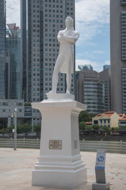 Singapur - 14 Kasım 2021: arkasında finans bölgesinin yüksek binaları olan Sir Stamford Raffles 'ın heykeli. Singapur 'un kurucusuydu..