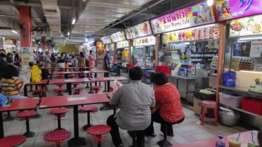 Singapur - 11 Ekim 2021 Singapur 'daki Hawker Center' da yemek yiyen insanlar. Hawker Center veya pişirilmiş gıda merkezi Singapur 'da bir açık hava tesisidir.