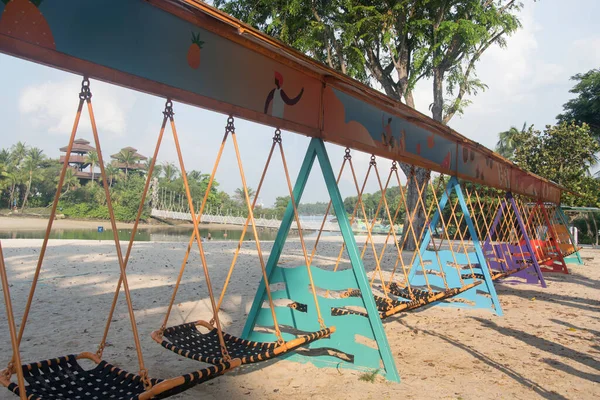 Singapur - 2 Nisan 2022 Sentosa, Singapur 'da Sentosa Hamak Swing. İkonik köprünün yakınındaki Palawan Sahili 'nde bulunan ultra uzun hamak salıncağı 18 kişiye sığabiliyor..