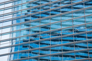 Glass facade with reflection in glass facade of building