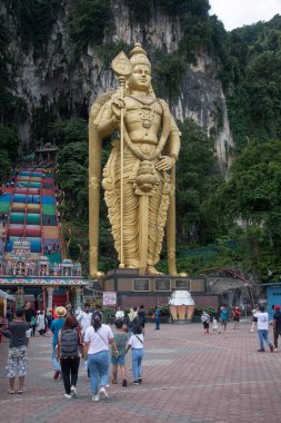 Kuala Lumpur, Malezya - Haziran 2022: Kuala Lumpur, Malezya 'daki Batu mağaralarına giden gökkuşağı merdivenine girmeden önce Murugan' ın dev altın heykeli. Hindu tanrı savaşı ve zafer..