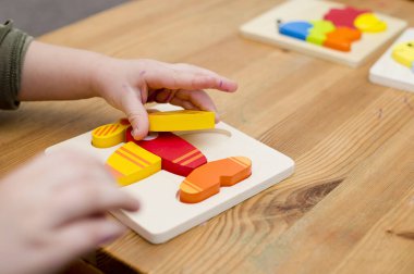 Jigsaw Bebek Erken Eğitim Oyuncakları 3 boyutlu Yapboz Çocuklar Yetenek Egzersizi Çocuklar Tahta Hediyeler. Erkek eli yapboz parçasında. Erken eğitim, odaklanma egzersizleri