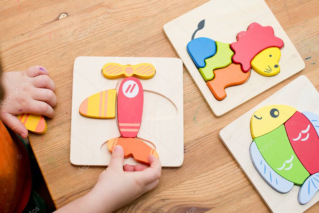 Jigsaw Baby Early Educational Toys 3D Puzzle Children Ability Exercise Kids Wooden Gifts. Boy hand on puzzle part. Early education, focus exercises