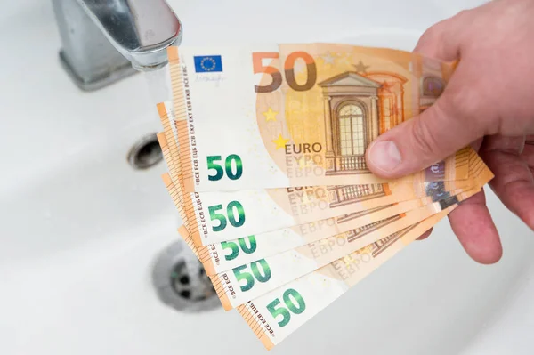 用欧元钞票把浴室的镀铬槽关上 提高水价和家庭预算规划的概念 增加消费 绿色能源 — 图库照片