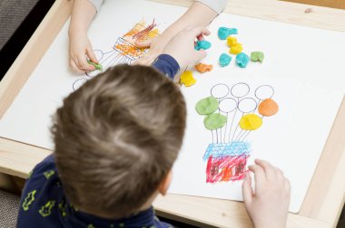 Küçük eller evi renkli balonlarla boyamış. Renkli mum kalemlerle. El-göz koordinasyonu için egzersiz, hayal gücünü canlandırma, yaratıcılık, iyi motor becerileri geliştirme.