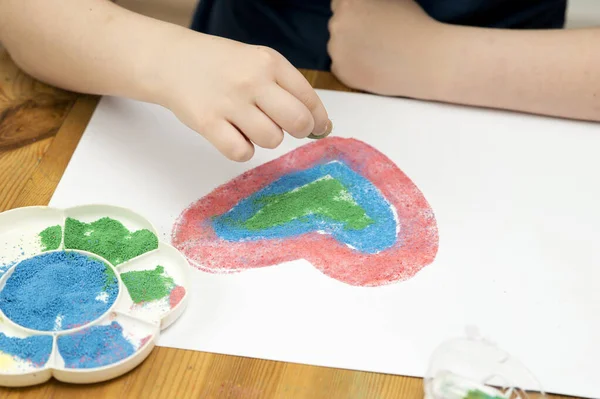 Niño Dibuja Con Arena Colores Sobre Papel Forma Corazón Tema —  Fotos de Stock