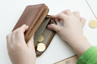 Çocuk cüzdandan para sayıyor. Küresel piyasadaki sembol değişiklikleri, ekonomik istikrarsızlık, enflasyon, yükselen fiyatlar, vergiler, kriz. Çocuk bütçesi, gelecekteki eğitim için tasarruf.
