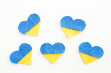 Ukrayna bayrağı teması. Beyaz arka planda keçeden yapılmış mavi ve sarı kalp şeklinde. Savaş konuları. Özgürlük savaşçıları. Ulusların desteği, birlik