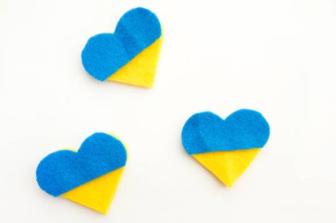 Ukrayna bayrağı teması. Beyaz arka planda keçeden yapılmış mavi ve sarı kalp şeklinde. Savaş konuları. Özgürlük savaşçıları. Ulusların desteği, birlik