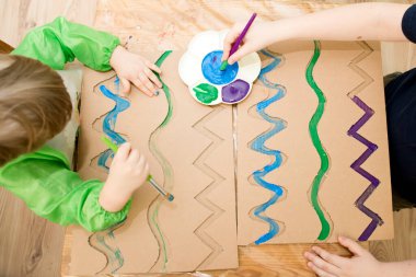 Sıfır kayıp. Arazi yapmak için oyulmuş karton kesilmiş ve yapıştırılmış. Çocuk onu deniz gibi boyuyor. Evdeki DIY oyunları. Okyanus konseptini koru.