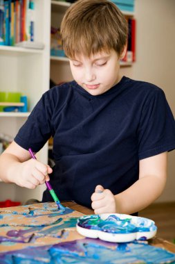 Sıfır kayıp. Arazi yapmak için oyulmuş karton kesilmiş ve yapıştırılmış. Çocuk onu deniz gibi boyuyor. Evdeki DIY oyunları. Okyanus konseptini koru.