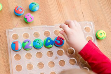 Oyun sayıyorum. Belirtilen numaraya göre doğru sayıda kapak al. Küçük çocuk görevini yerine getirdi. Erken eğitim. Oyuncak hayal gücünü, yaratıcılığı, el-göz koordinasyonunu canlandırır..