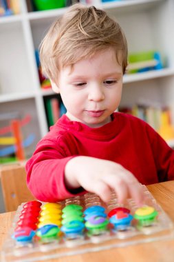 Oyun sayıyorum. Belirtilen numaraya göre doğru sayıda kapak al. Küçük çocuk görevini yerine getirdi. Erken eğitim. Oyuncak hayal gücünü, yaratıcılığı, el-göz koordinasyonunu canlandırır..