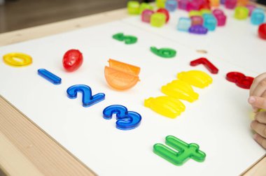 Sayılar ve oyuncaklar. Yapay meyve ve rakamlar. Çocukların saymayı öğrenmesi için bir fikir. Montessori kavramı, erken eğitim.