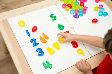 Sayılar ve oyuncaklar. Yapay meyve ve rakamlar. Çocukların saymayı öğrenmesi için bir fikir. Montessori kavramı, erken eğitim.