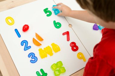 Sayılar ve oyuncaklar. Yapay meyve ve rakamlar. Çocukların saymayı öğrenmesi için bir fikir. Montessori kavramı, erken eğitim.