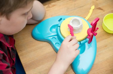 Genç heykeltıraş. Ot hızlı hazırlanan kil ile çalıyor. İlk sanat dersleri. Yaratıcılık eğitimi odaklanma, görevi tamamlama. Engelli ve Otizmli Çocuklar İçin İstihdam Merkezi.