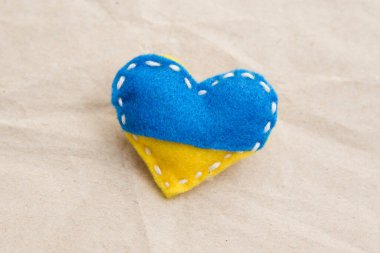 Ukrayna bayrağı teması. Kalp şeklindeki rozet mavi ve sarı dolgulu keçeden yapılmış. Savaş konuları. Özgürlük savaşçıları. Ulusların desteği, birlik. Barış için dua et. Savaş yok..
