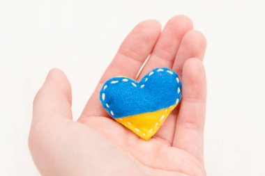 Ukrayna bayrağı teması. Kalp şeklindeki rozet mavi ve sarı dolgulu keçeden yapılmış. Savaş konuları. Özgürlük savaşçıları. Ulusların desteği, birlik. Barış için dua et. Savaş yok..